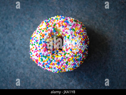 A vanilla dip donut (sprinkle donut, rainbow sprinkle donut) from Tim Hortons, a popular Canadian fast food restaurant and donut shop. Stock Photo