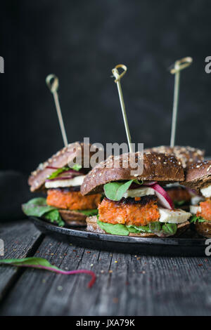 Vegetarian tofu carrot burger sliders served on iron skillet. Closeup view, toned image Stock Photo