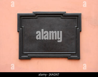 Blank cast-iron plaque on stone wall. Add your own text or image. Clipping path is included Stock Photo