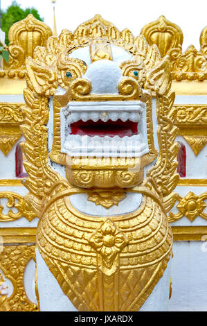 Statue of golden Singha or lion guardian situated in temple of Phra That Phanom Nakhon Phanom Province, northeastern Thailand Stock Photo