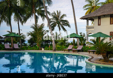 Phan Thiet, Vietnam - Mar 26, 2017. Swimming pool of resrort with palm trees in Phan Thiet, Vietnam. Phan Thiet belongs to Binh Thuan province and loc Stock Photo