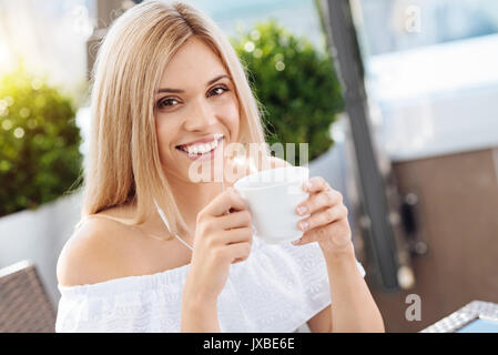 Delighted happy woman enjoying her drink Stock Photo