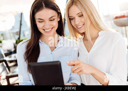 Happy female colleagues using a tablet Stock Photo