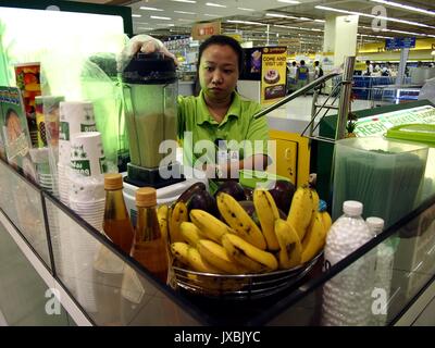 ANGONO, RIZAL, PHILIPPINES - AUGUST 12, 2017: Food kiosk employee prepares a fruit shake for a customer Stock Photo