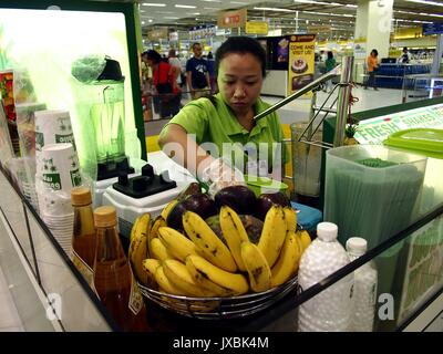 ANGONO, RIZAL, PHILIPPINES - AUGUST 12, 2017: Food kiosk employee prepares a fruit shake for a customer Stock Photo