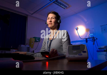 Michelle Davidson (Queen's Nurse) doing out-of-hours telephone triage at the GP Clinic, based at Weston General Hospital, Weston-Super-Mare, Somerset. Stock Photo