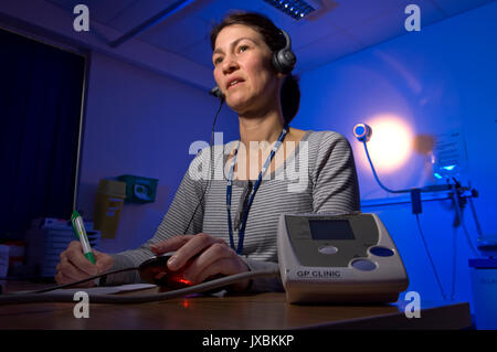 Michelle Davidson (Queen's Nurse) doing out-of-hours telephone triage at the GP Clinic, based at Weston General Hospital, Weston-Super-Mare, Somerset. Stock Photo