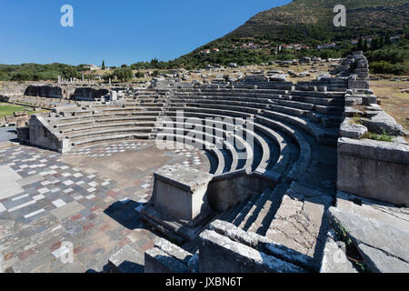 The Ekklesiasterion or assembly hall at Ancient Messini with the village of Mavromati in the background Stock Photo