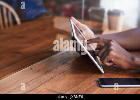 Young man sitting at a sidewalk cafe counter working online Stock Photo