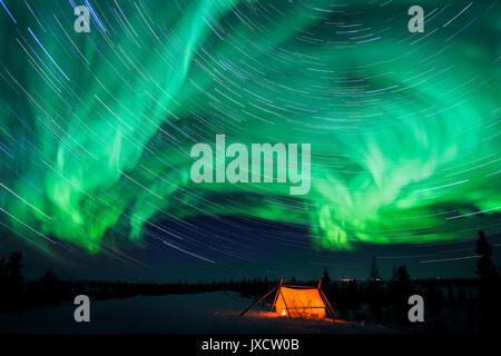 Nightsky and trappers tent lit up with aurora borealis, northern lights, and stars, wapusk national park, Manitoba, Canada. Stock Photo
