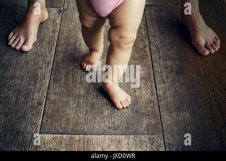 happy baby learning to walk with mother help Stock Photo