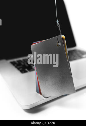 Isolated computer laptop with credit cards and fishing hook. Stock Photo