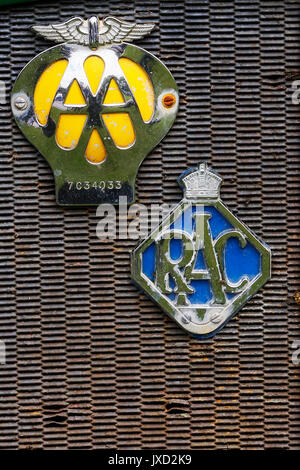 Vintage AA (Automobile Association) and RAC (Royal Automobile Club) badges mounted on a rusting radiator grill. Stock Photo