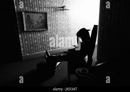 A cowboy with boots propped up in the haunted hallway of the St. James Hotel where 26 murders took place. Stock Photo