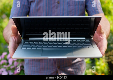 Man holding notebook computer in hands Stock Photo
