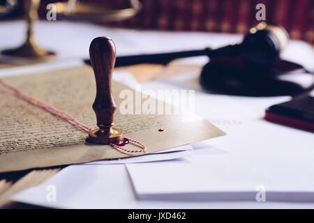 Metal wax notary public stamper on old document. Law office Stock Photo