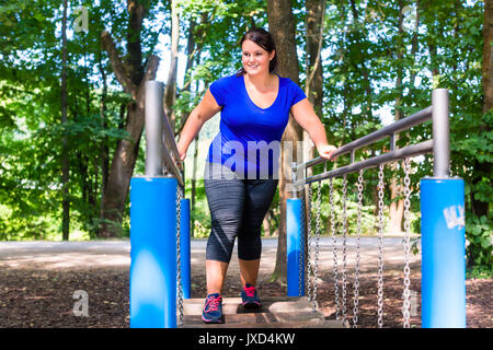 Overweight woman in climbing park doing sport Stock Photo