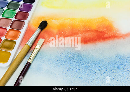 artist paintbrushes and palette of aquarelle paints on watercolor painting background Stock Photo