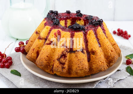 Freshly baked cake with summer berries, jug of milk on a white background Stock Photo
