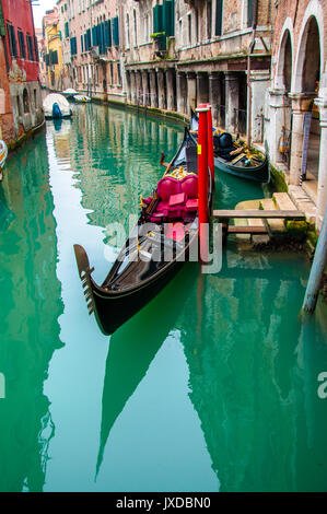 Small boat on a canal street in Venice with beautiful colorful houses ...