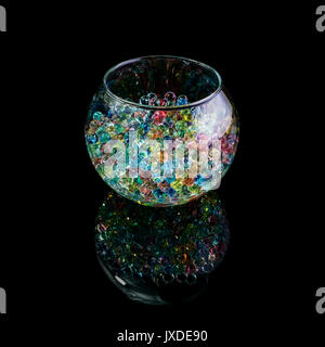 Colored hydrogel balls in a glass vase isolated on a black background Stock Photo