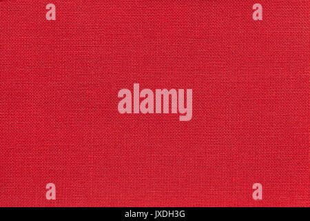 Dark bright red background from a textile material with wicker pattern, closeup. Structure of the ruby fabric with natural texture. Cloth backdrop. Stock Photo