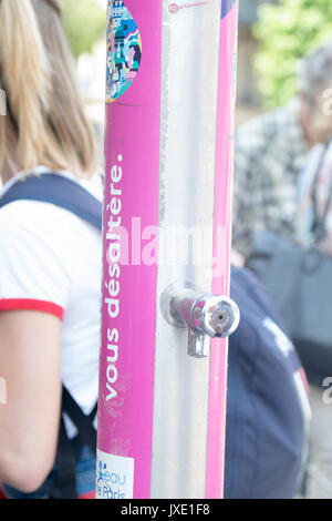 People filling up water in a plastic bottle at a public water fountain in Paris Stock Photo