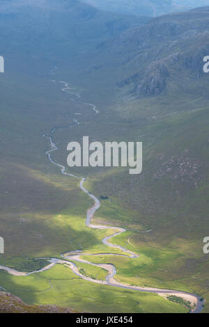 Two mountain rivers running down through mountain valleys in the Scottish Highlands meet and join together to one in a field of peat and heather Stock Photo