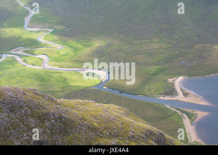 Two mountain rivers running down through mountain valleys in the Scottish Highlands  join together in a field of peat and heather before entering the  Stock Photo