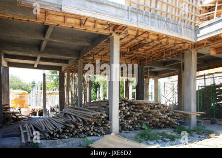 Bamboo/Timber sonstruction site in Bali, Indonesia - with piles of bamboo poles in foreground Stock Photo