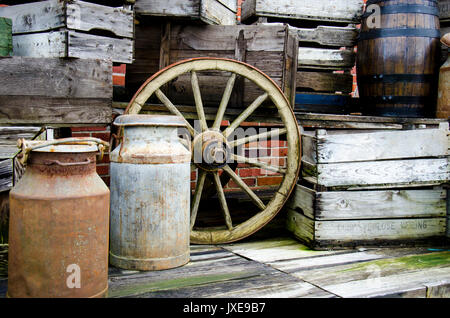 Arrangement of old stuff - Metal milk barrel, wooden boxes, fruit cases and other old stuff - Vintage Stock Photo