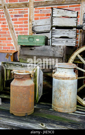 Arrangement of old stuff - Metal milk barrel, wooden boxes, fruit cases and other old stuff - Vintage Stock Photo