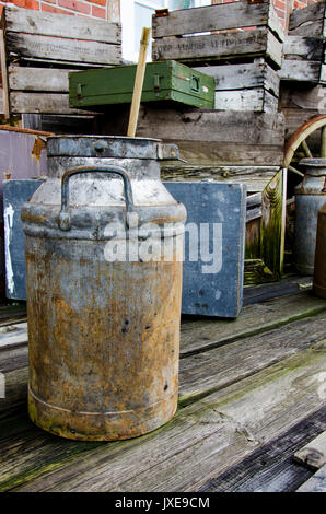 Arrangement of old stuff - Metal milk barrel, wooden boxes, fruit cases and other old stuff - Vintage Stock Photo