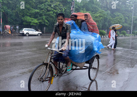 Dhaka, Bangladesh. 16th Aug, 2017.  Bangladeshi rickshaw pullers make their way with commuters during a monsoon rain in Dhaka, Bangladesh. Credit: SK Hasan Ali/Alamy Live News Stock Photo