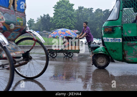Dhaka, Bangladesh. 16th Aug, 2017.  A Bangladeshi man pushes cart of a disabled beggar during monsoon rain in Dhaka, Bangladesh. Credit: SK Hasan Ali/Alamy Live News Stock Photo