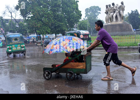 Dhaka, Bangladesh. 16th Aug, 2017.  A Bangladeshi man pushes cart of a disabled beggar during monsoon rain in Dhaka, Bangladesh. Credit: SK Hasan Ali/Alamy Live News Stock Photo
