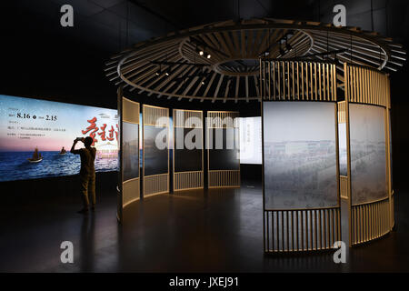 (170816) -- GUANGZHOU, Aug. 16, 2017 (Xinhua) -- A man takes photos of an exhibition at the cultural corridor in the Baiyun International Airport of Guangzhou, capital of south China's Guangdong Province, Aug. 16, 2017. Guangzhou Baiyun International Airport, together with the provincial museum, held a public exhibition themed on the Maritime Silk Road, the first one at the historical cultural corridor which officially opened here Wednesday. (Xinhua/Liang Xu)(wjq) Stock Photo