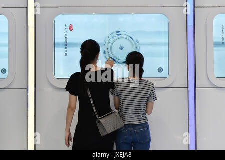 (170816) -- GUANGZHOU, Aug. 16, 2017 (Xinhua) -- Visitors experience a touch screen displayed at the cultural corridor in the Baiyun International Airport of Guangzhou, capital of south China's Guangdong Province, Aug. 16, 2017. Guangzhou Baiyun International Airport, together with the provincial museum, held a public exhibition themed on the Maritime Silk Road, the first one at the historical cultural corridor which officially opened here Wednesday. (Xinhua/Liang Xu)(wjq) Stock Photo