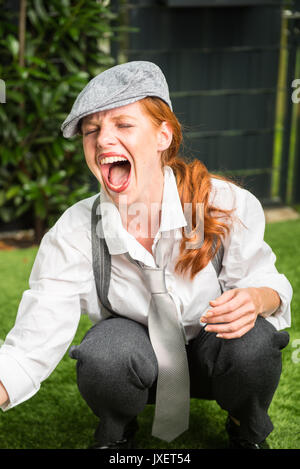 young red-haired woman as a man dressed in the garden Stock Photo