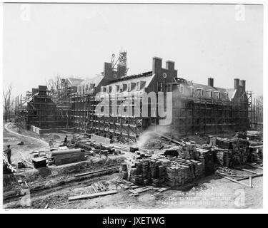Alumni Memorial Residences NW view of the AMR?, Glass and architectural details in place, Tiles missing from mansard roof, Piles of construction material present, Water or smoke machine being used, 1923. Stock Photo