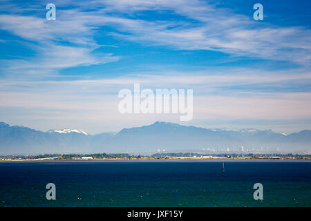 View from the sea towards Vancouver, Canada with the snow covered Coast Mountains in the background. Stock Photo