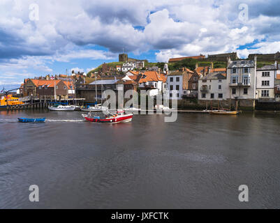 dh Fishing boat fisherman WHITBY NORTH YORKSHIRE Returning to town houses abbey boats england village coast harbour spring uk Stock Photo