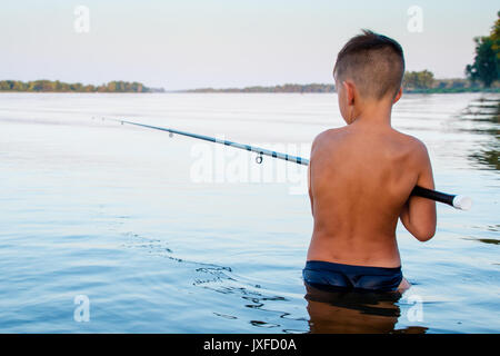 Boy fishing waist deep in water Stock Photo - Alamy