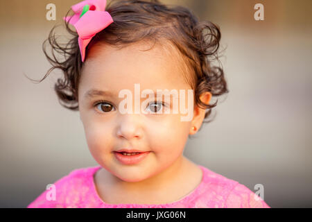 Baby girl dressed in pink looking at the camera Stock Photo