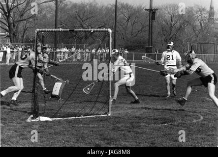 Lacrosse Action shot taken during an unidentified match, Group of players surround the goal, trying to prevent Hopkins player from making a goal, 1950. Stock Photo