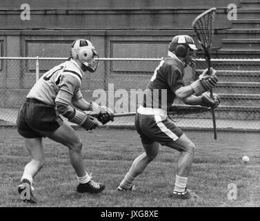 Lacrosse Action shot taken during an unidentified game, A Hopkins player and a member of the opposing team both endeavor to pick up the ball from the ground, 1950. Stock Photo