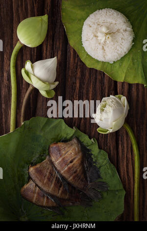 thai food rice and dried salted damsel fish fried with flower lotus jasmine decoration on wooden background beautiful flat lay still life rustic asia Stock Photo