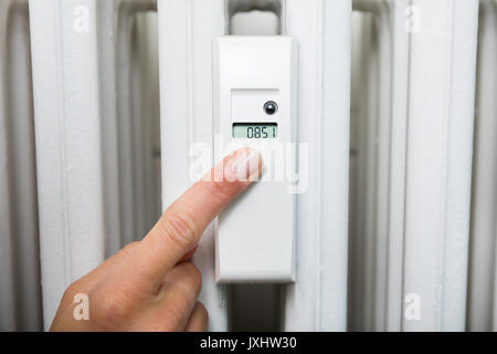 Close-up Of Woman Taking Heating Consumption Reading From Digital Thermostat Stock Photo