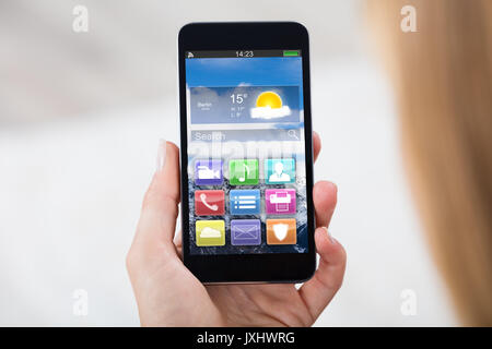 Close-up Of Woman Hand Holding Mobile Phone Showing Different Colorful Application Stock Photo