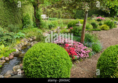 Boxwood (Buxus) and azaleas (Rhododendron) at an brook. Design: Marianne  and Detlef Ldke Stock Photo - Alamy